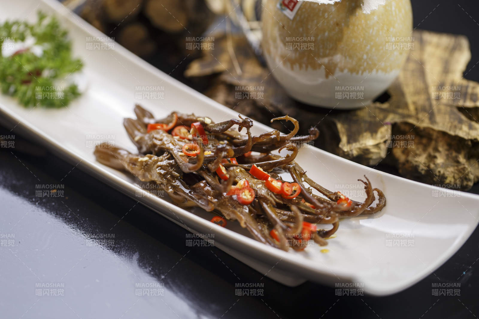 月牙形瓷盘装的川味鸭舌图片