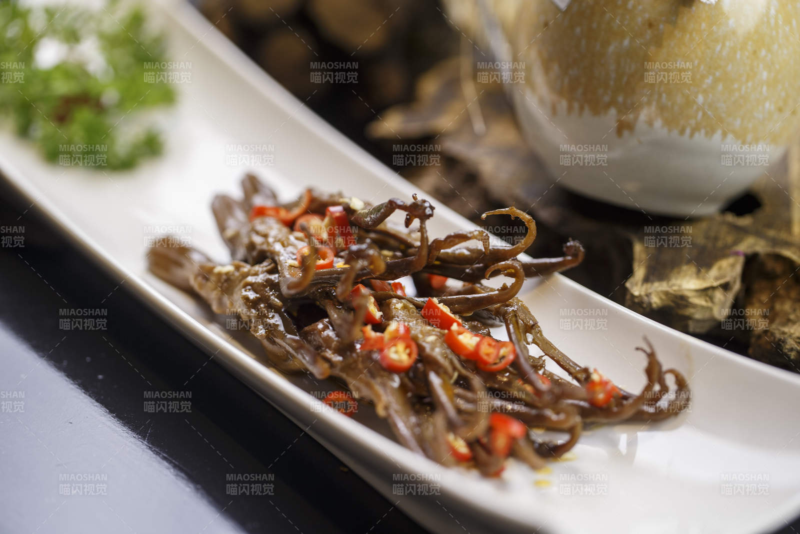 月牙形瓷盘装的川味鸭舌图片