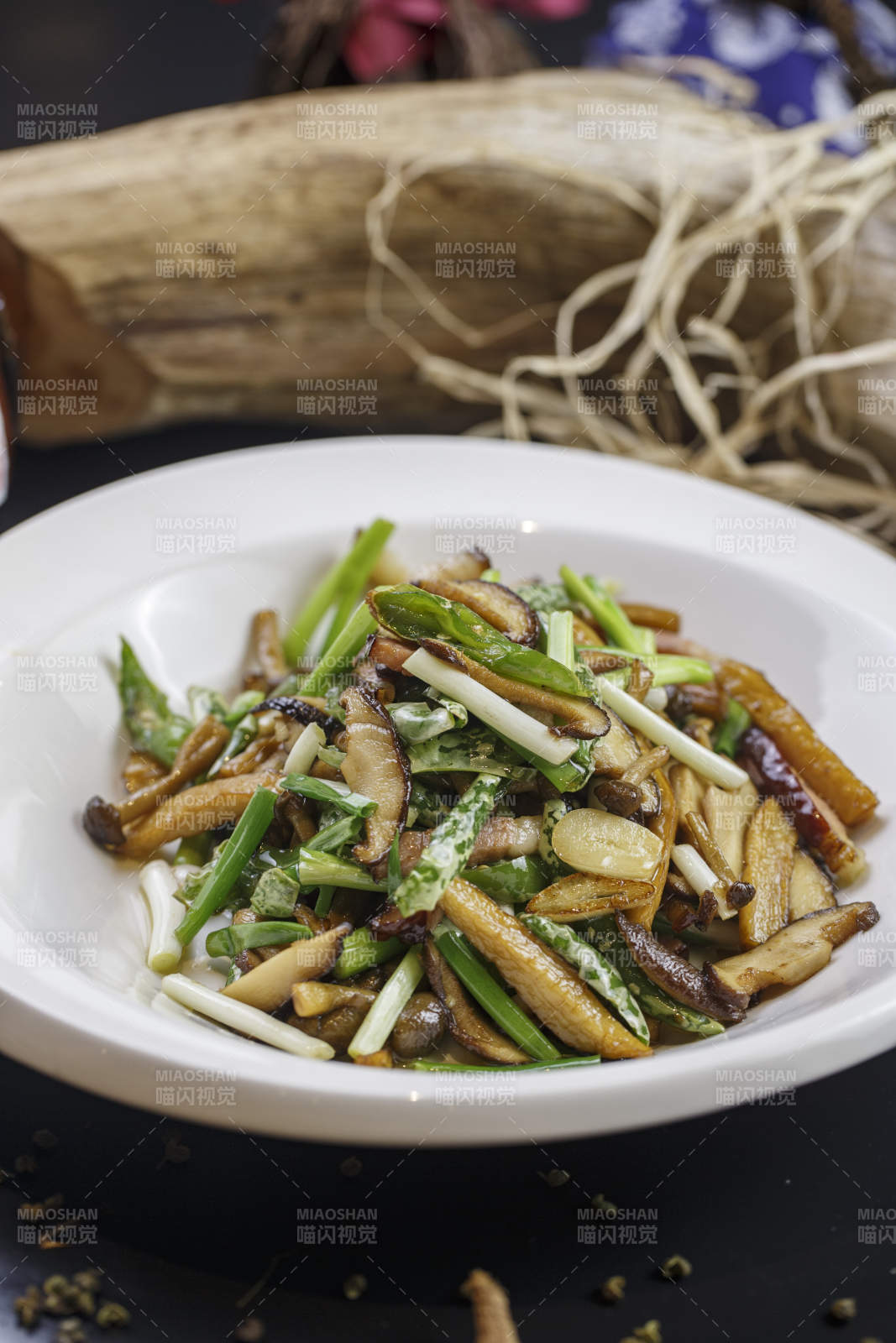 圓形白色瓷盤裝的臘肉小炒山珍菌