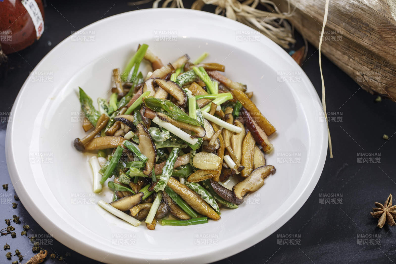 圓形白色瓷盤裝的臘肉小炒山珍菌