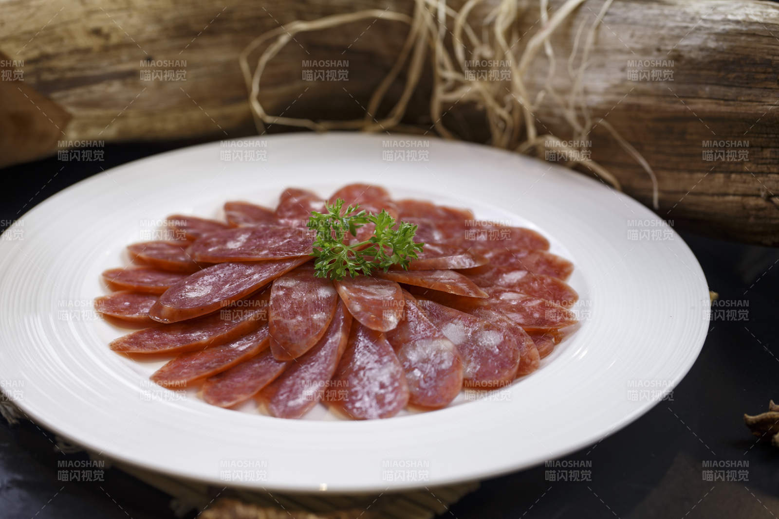 圆形白瓷盘装的川味甜腊肠