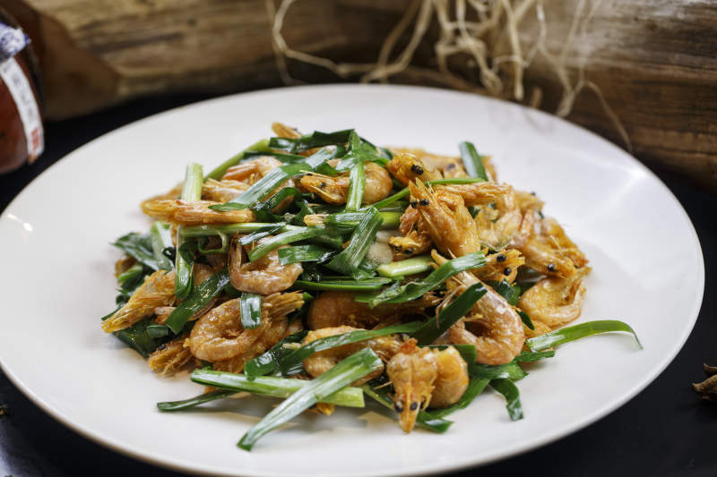 圆形白瓷盘装的韭菜炝炒小河虾