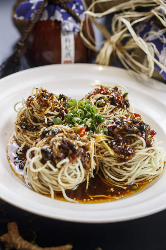 圆形白瓷盘装的麻辣鸡丝担担面