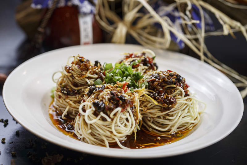 圆形白瓷盘装的麻辣鸡丝担担面