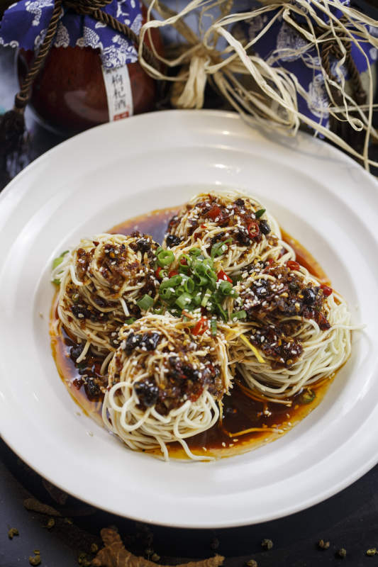 圆形白瓷盘装的麻辣鸡丝担担面