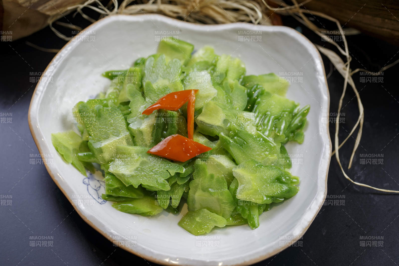 浪花边瓷盘装的炝炒苦瓜