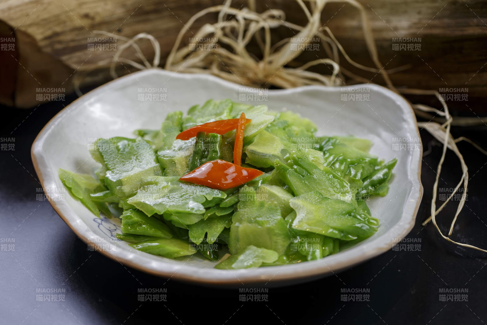 浪花边瓷盘装的炝炒苦瓜