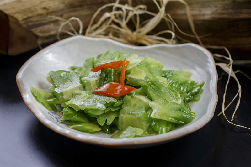 浪花边瓷盘装的炝炒苦瓜