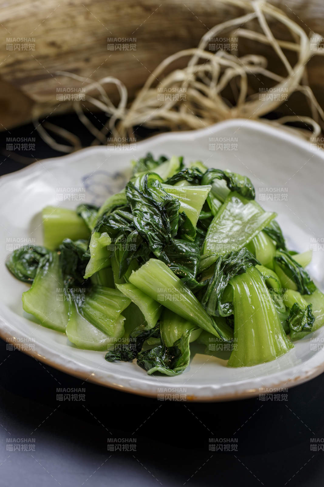 浪花边瓷盘装的炝炒油菜