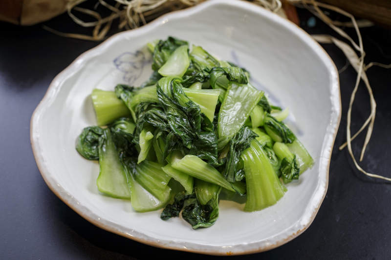 浪花边瓷盘装的炝炒油菜