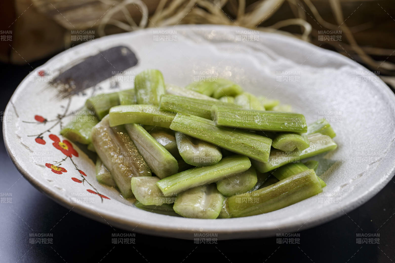 梅花图案的瓷盘装的炝炒丝瓜