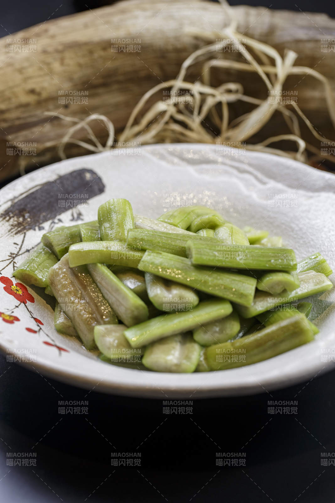 梅花图案的瓷盘装的炝炒丝瓜