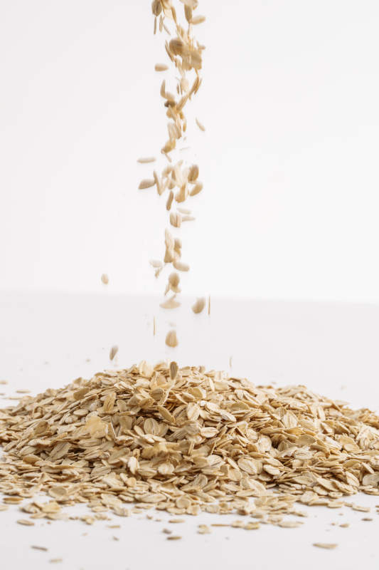 倾倒在白色背景上的健康食品燕麦片