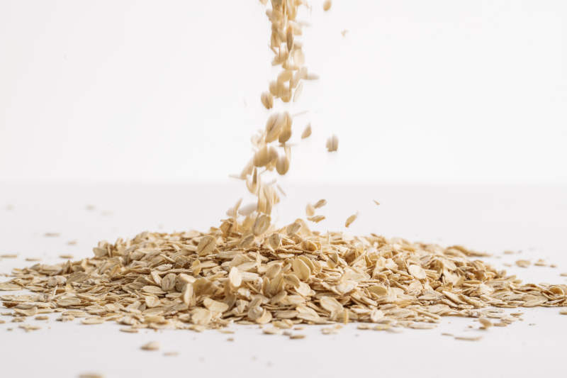 倾倒在白色背景上的健康食品燕麦片