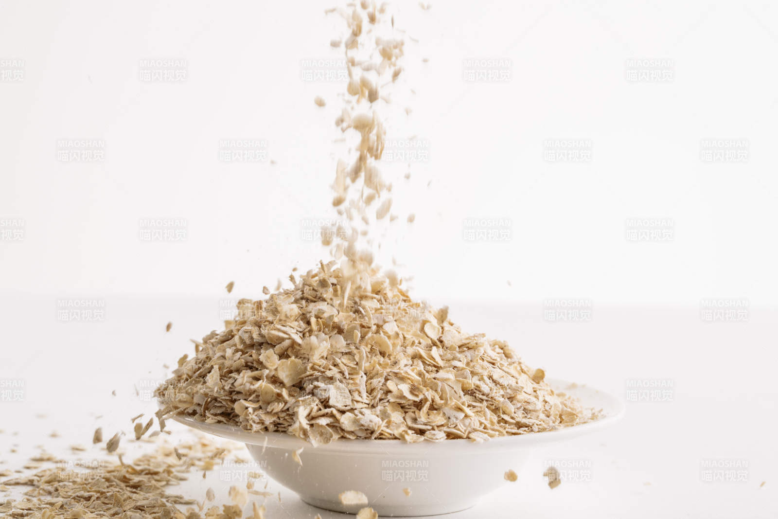 倾倒在白色背景上的健康食品燕麦片