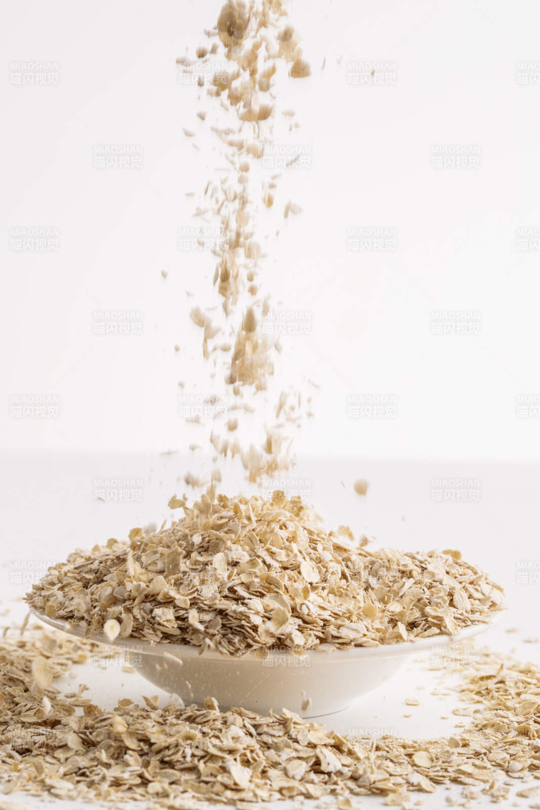 倾倒在白色背景上的健康食品燕麦片