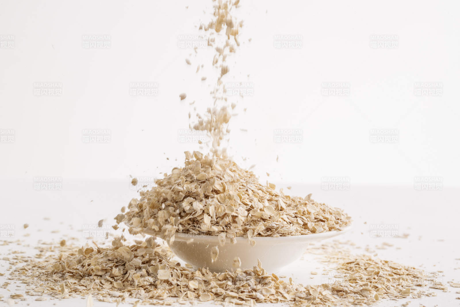 倾倒在白色背景上的健康食品燕麦片