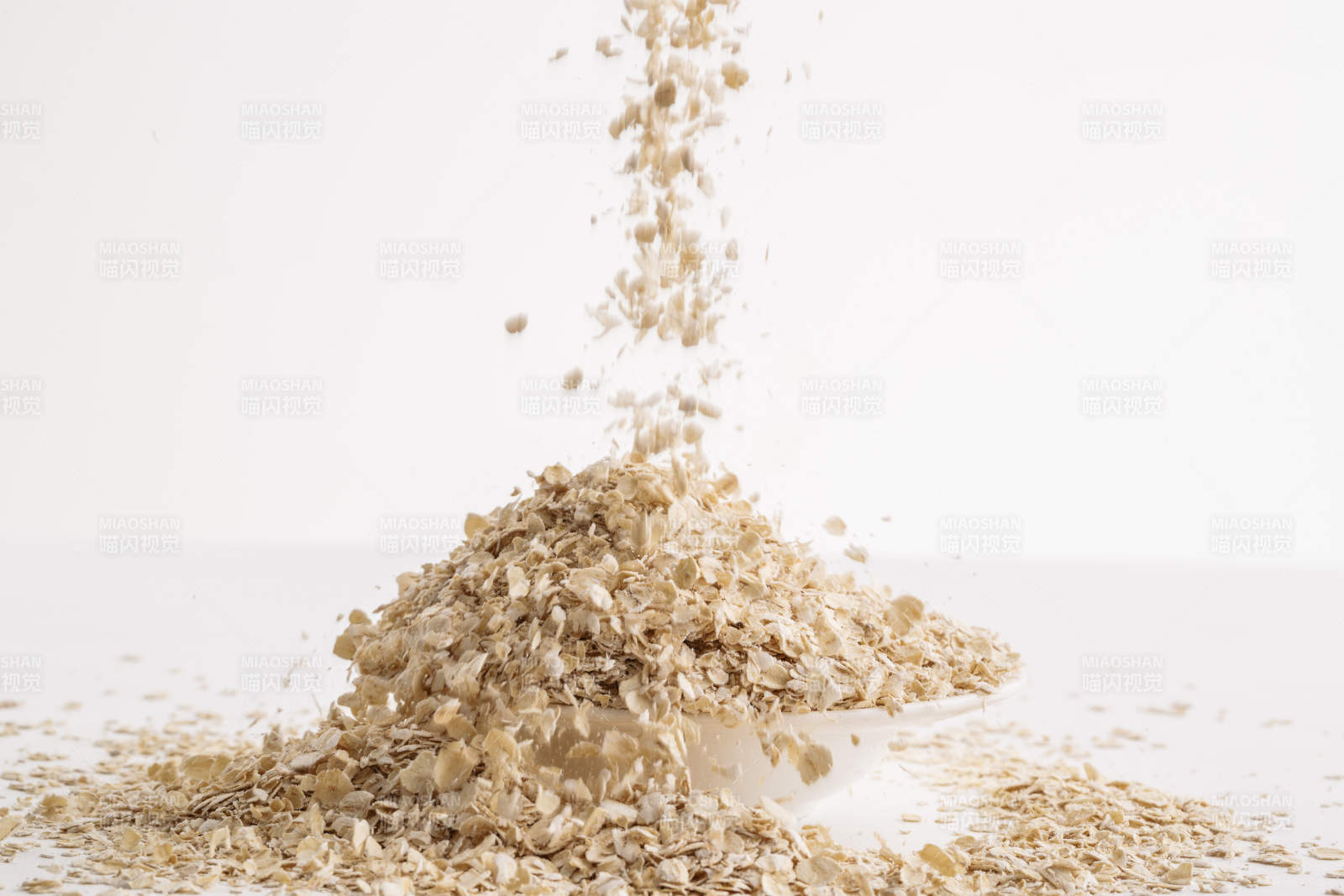 倾倒在白色背景上的健康食品燕麦片