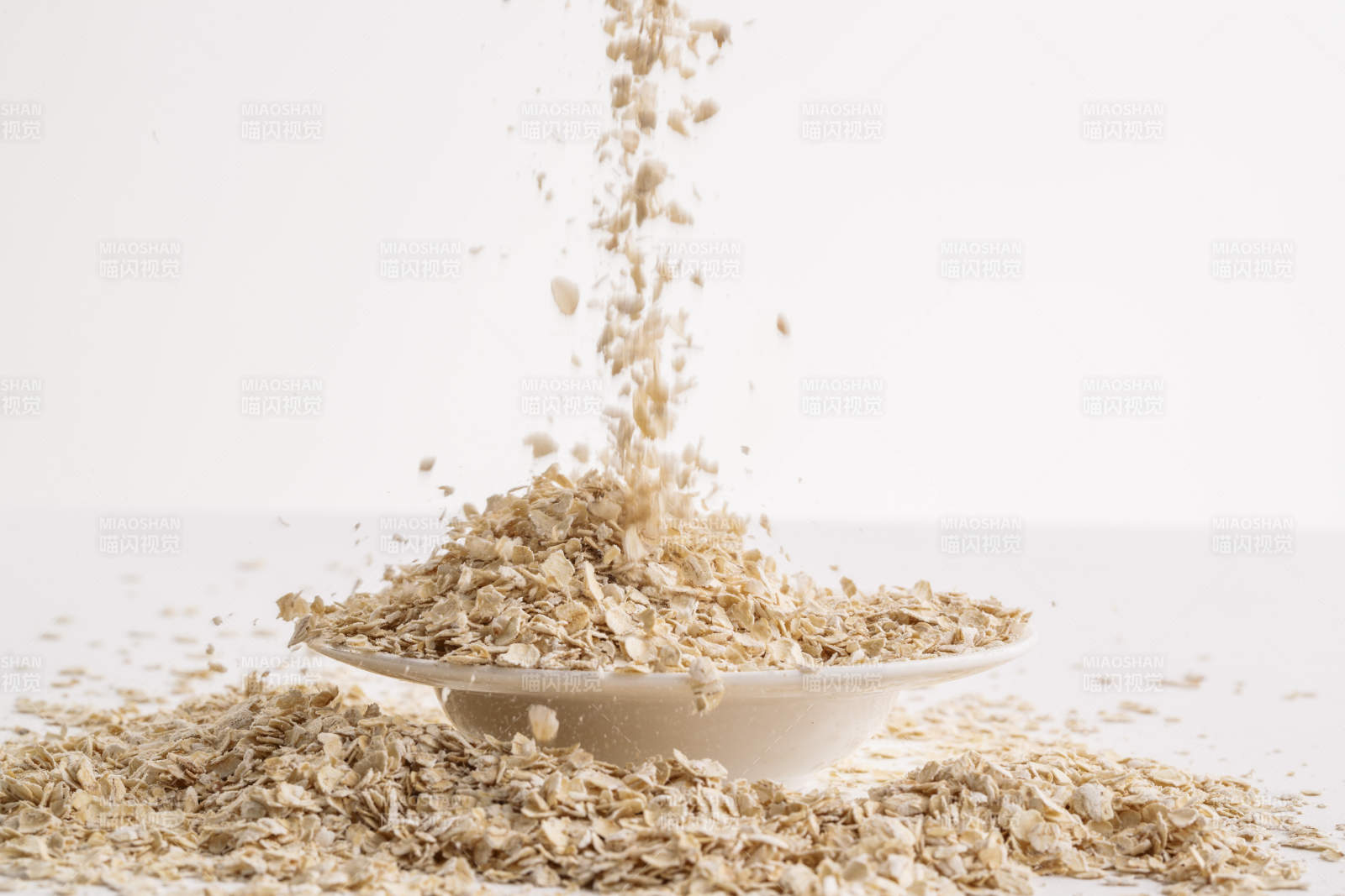 倾倒在白色背景上的健康食品燕麦片