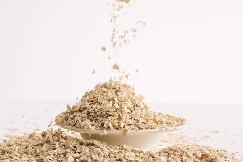 倾倒在白色背景上的健康食品燕麦片