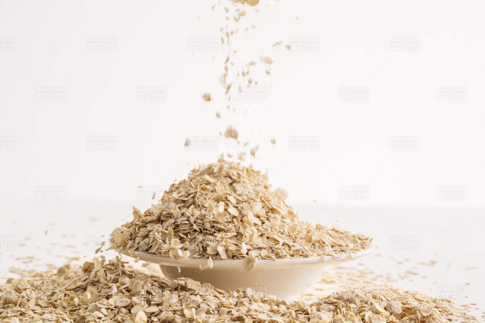 倾倒在白色背景上的健康食品燕麦片