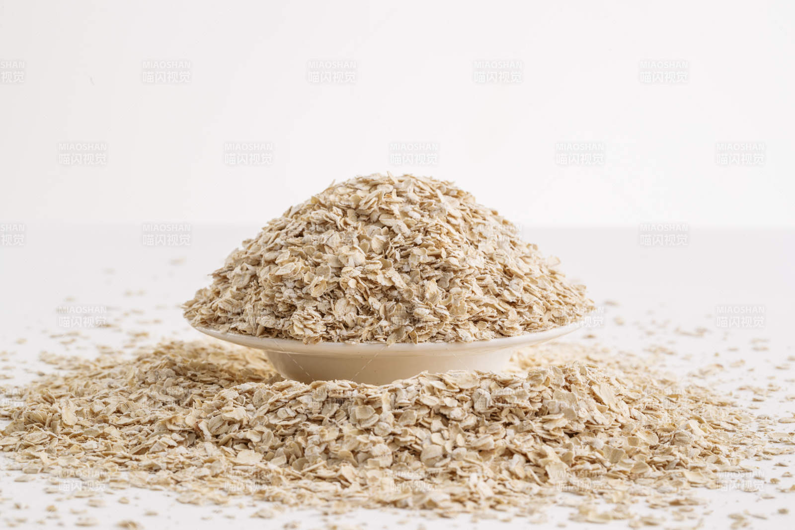 倾倒在白色背景上的健康食品燕麦片