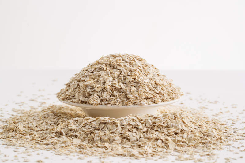 倾倒在白色背景上的健康食品燕麦片