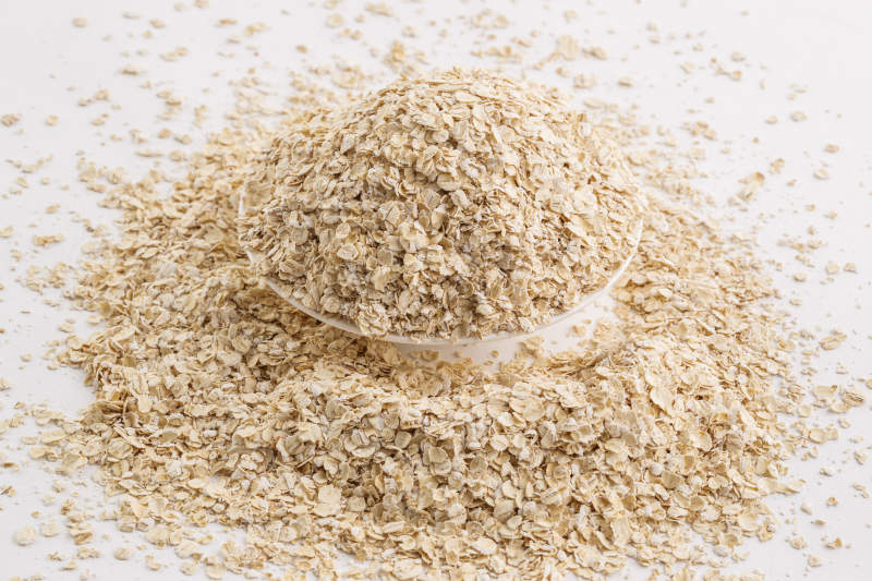 倾倒在白色背景上的健康食品燕麦片