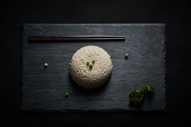 黑色青石板上摆放的燕麦米及蒸燕麦米饭