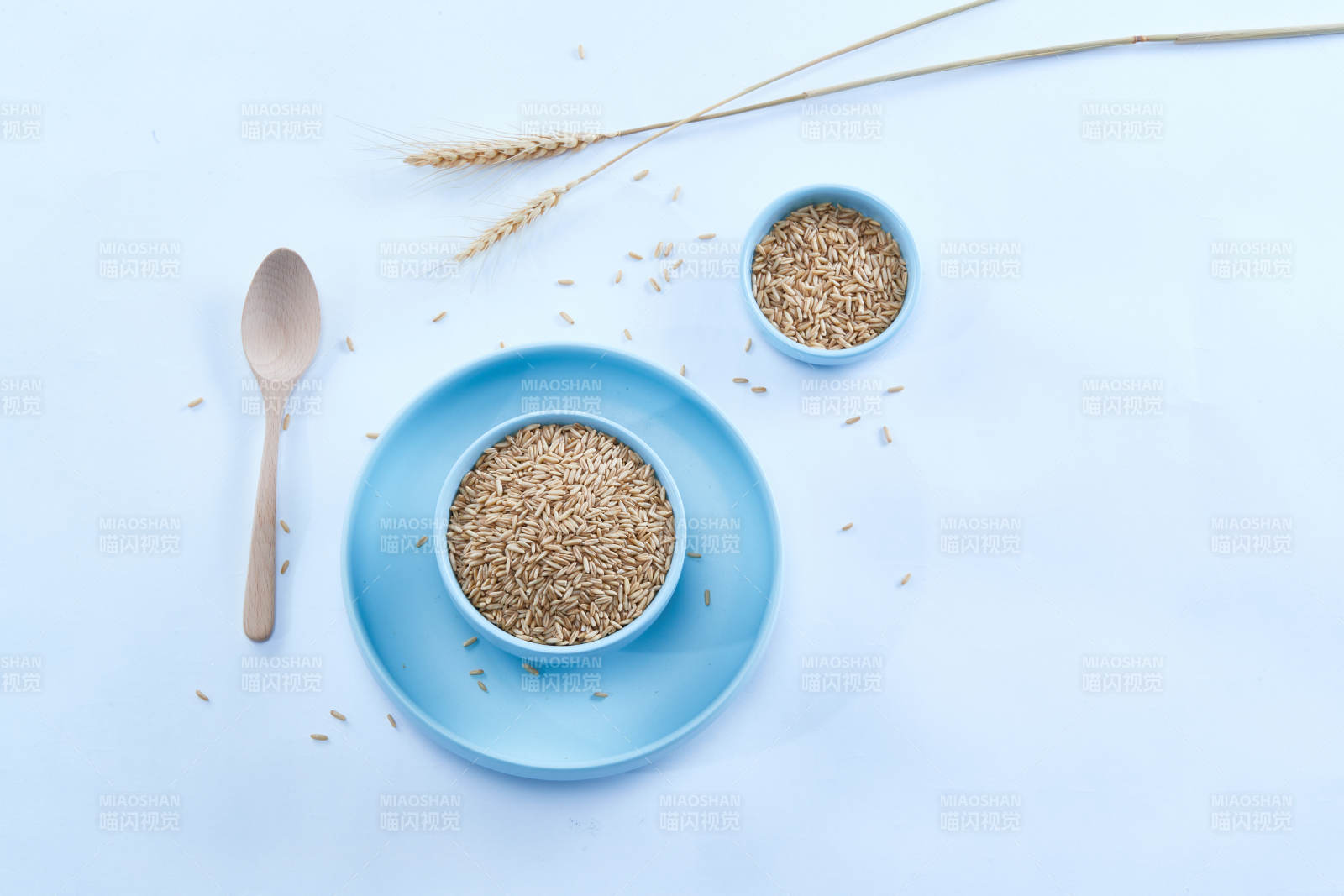 白色纸背景上的青釉瓷餐具及木质餐具装的燕麦米-摄影图