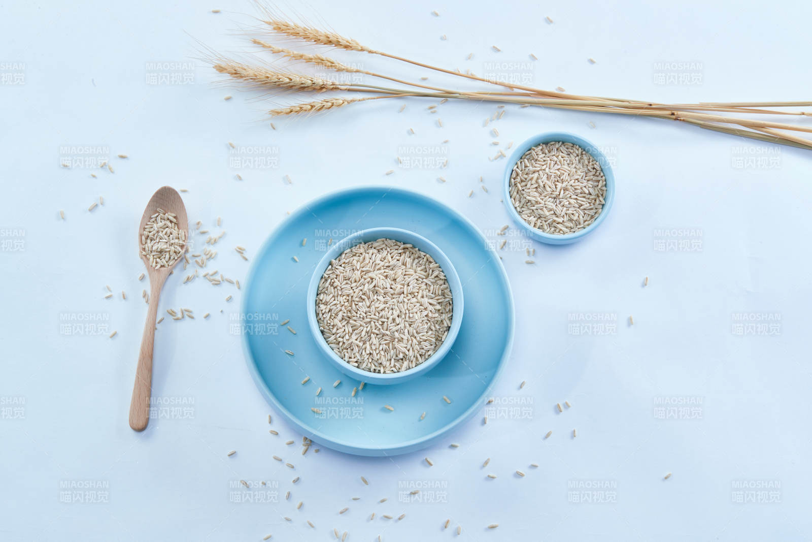 白色纸背景上的青釉瓷餐具及木质餐具装的燕麦米-摄影图