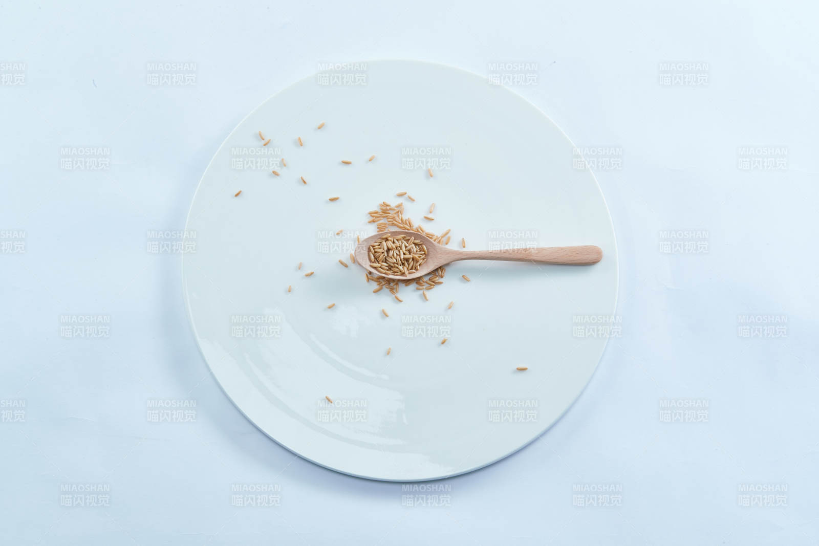 白色纸背景上的青釉瓷餐具及木质餐具装的燕麦米-摄影图