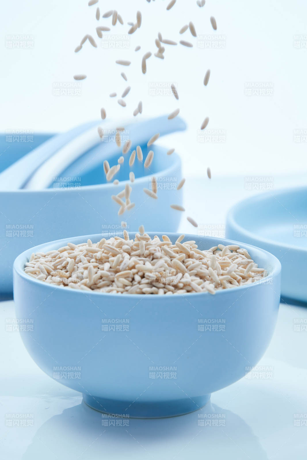 白色纸背景上的青釉瓷餐具及木质餐具装的燕麦米