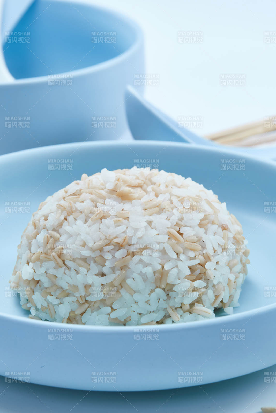 白色纸背景上的青釉瓷餐具及木质餐具装的燕麦米