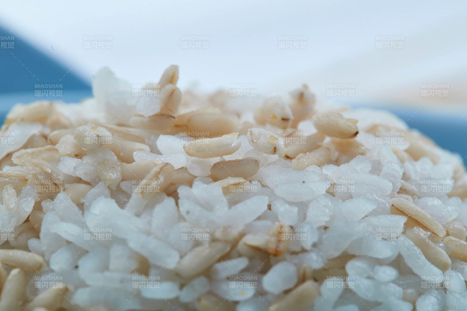 白色纸背景上的青釉瓷餐具及木质餐具装的燕麦米