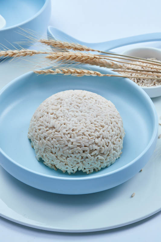 白色纸背景上的青釉瓷餐具及木质餐具装的燕麦米