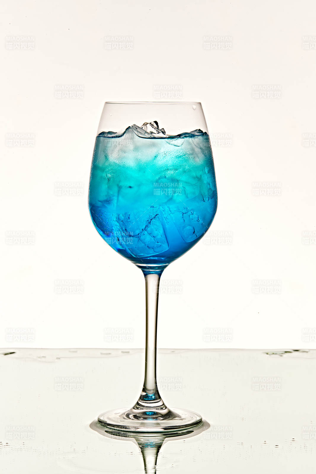 酒杯中的清凉蓝橙汁百加得调制的鸡尾酒