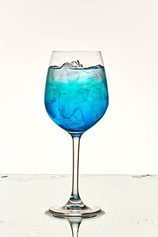 酒杯中的清凉蓝橙汁百加得调制的鸡尾酒