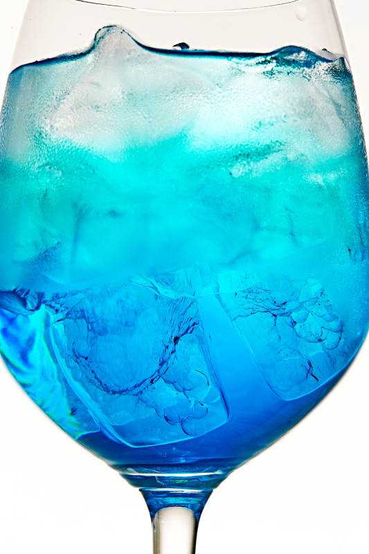 酒杯中的清凉蓝橙汁百加得调制的鸡尾酒