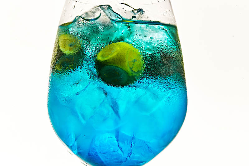 酒杯中的清凉蓝橙汁百加得调制的鸡尾酒