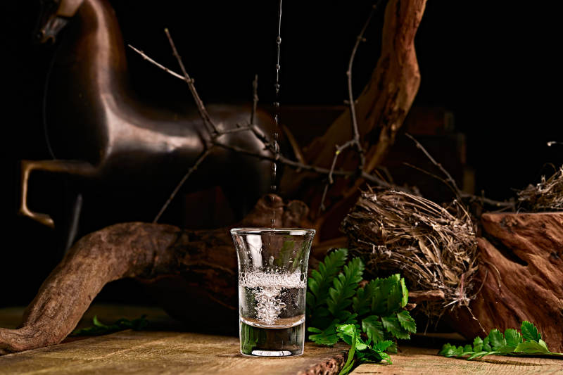 木板上摆放的酒具倒入清澈的白酒激起酒花