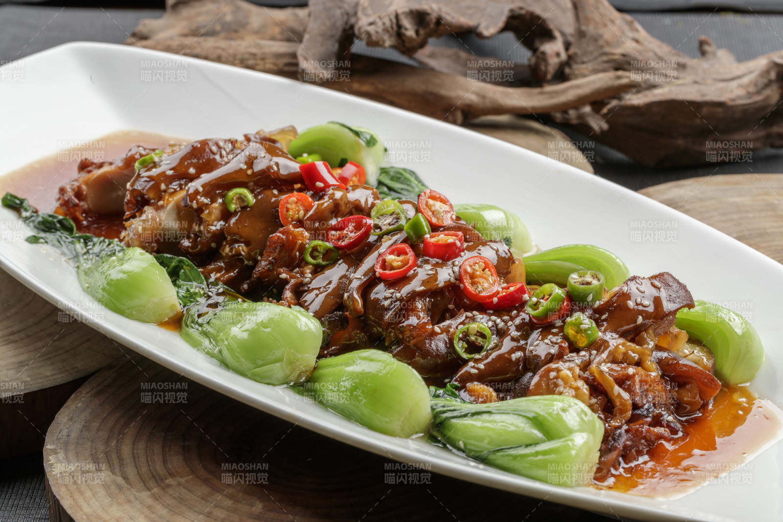 白色瓷盘装的香辣红烧大肘子肉-摄影图