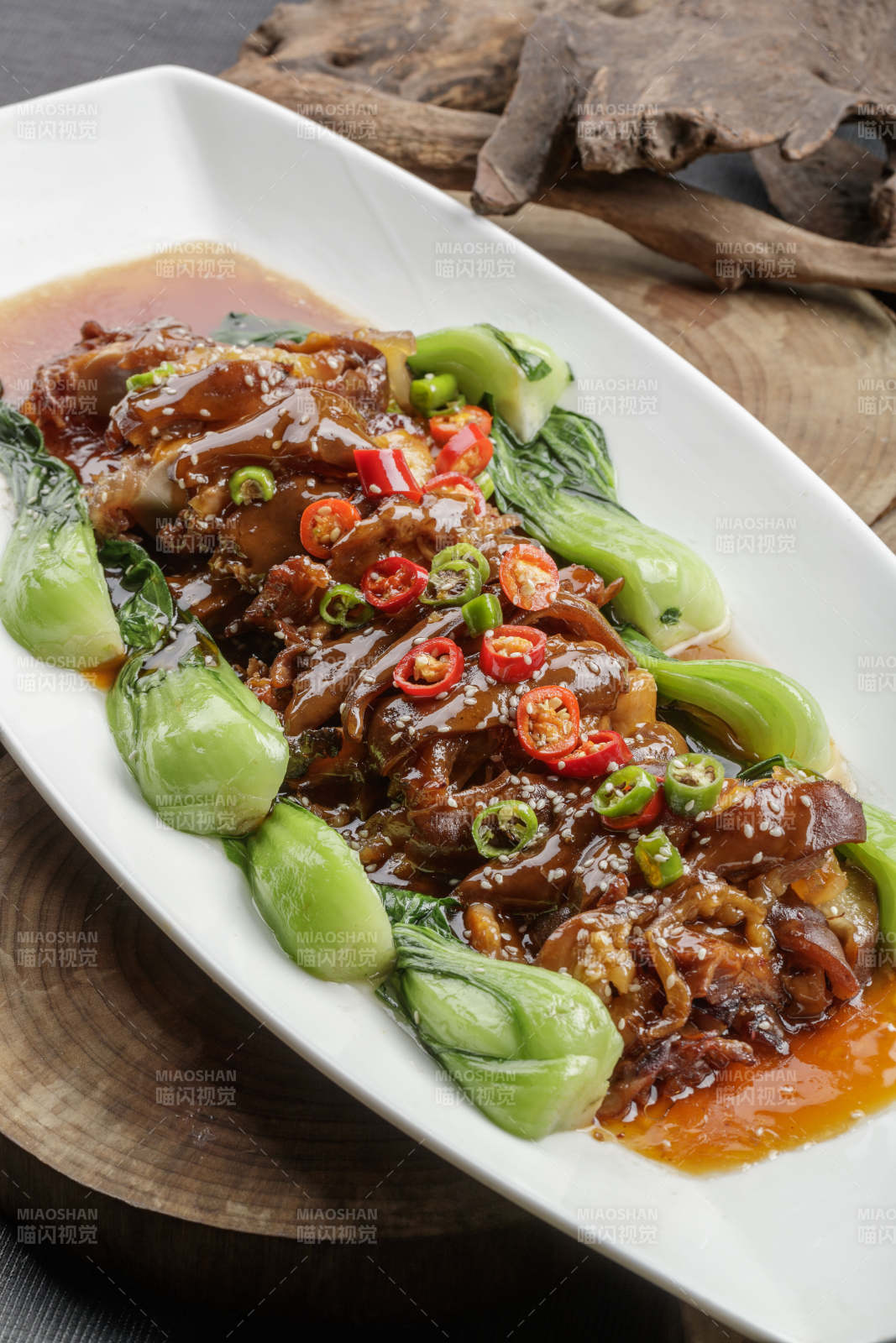 白色瓷盘装的香辣红烧大肘子肉-摄影图