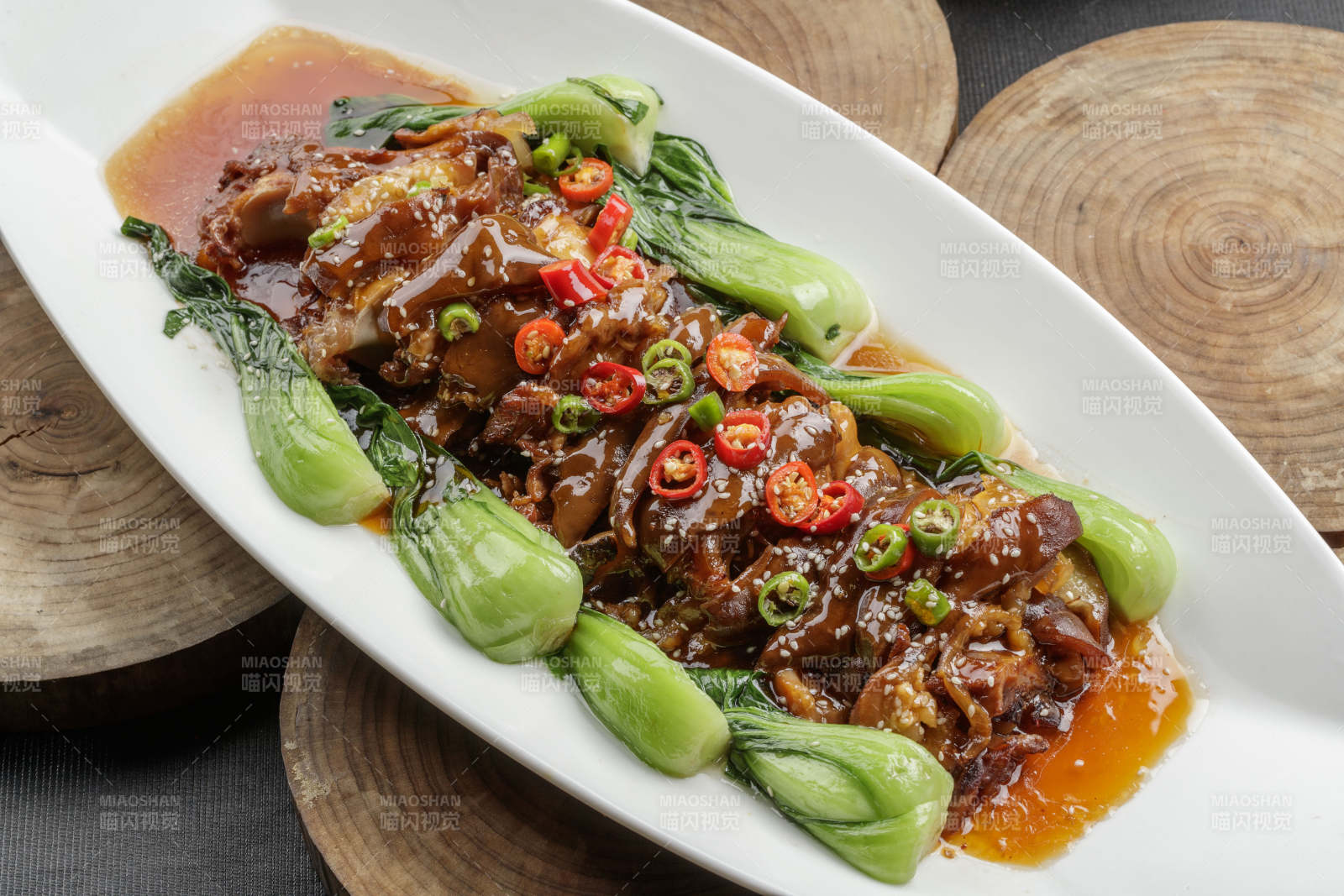 白色瓷盘装的香辣红烧大肘子肉-摄影图