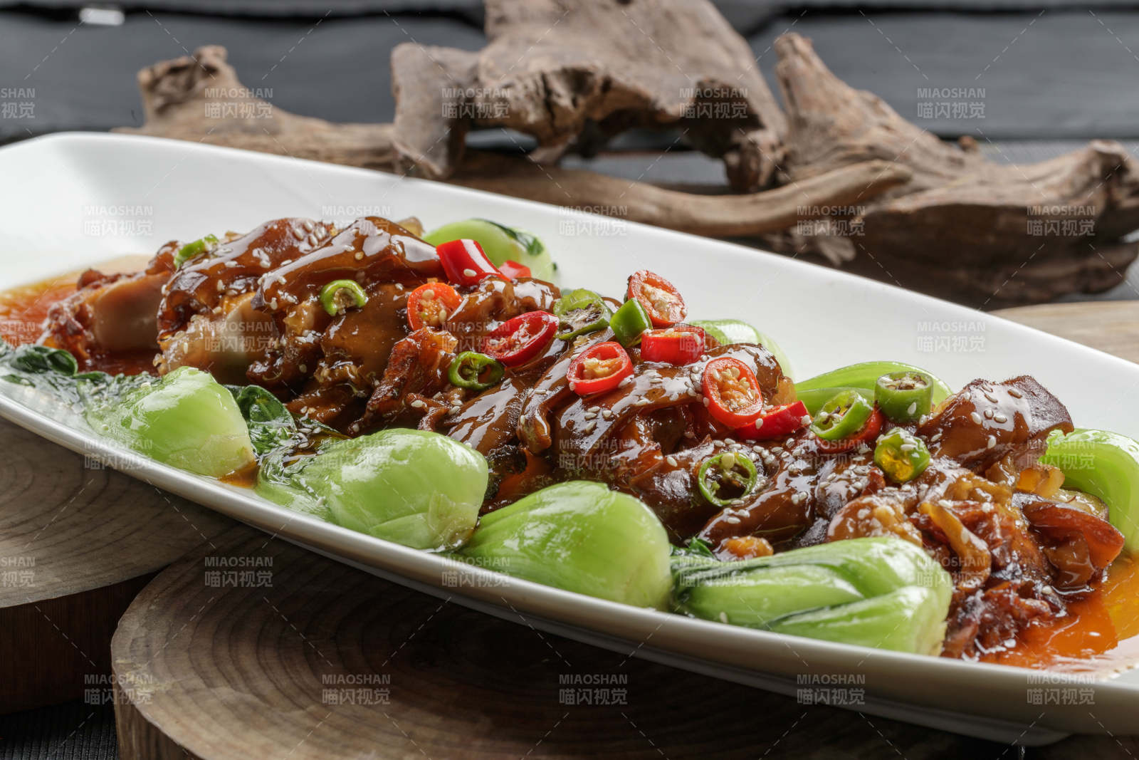 白色瓷盘装的香辣红烧大肘子肉-摄影图