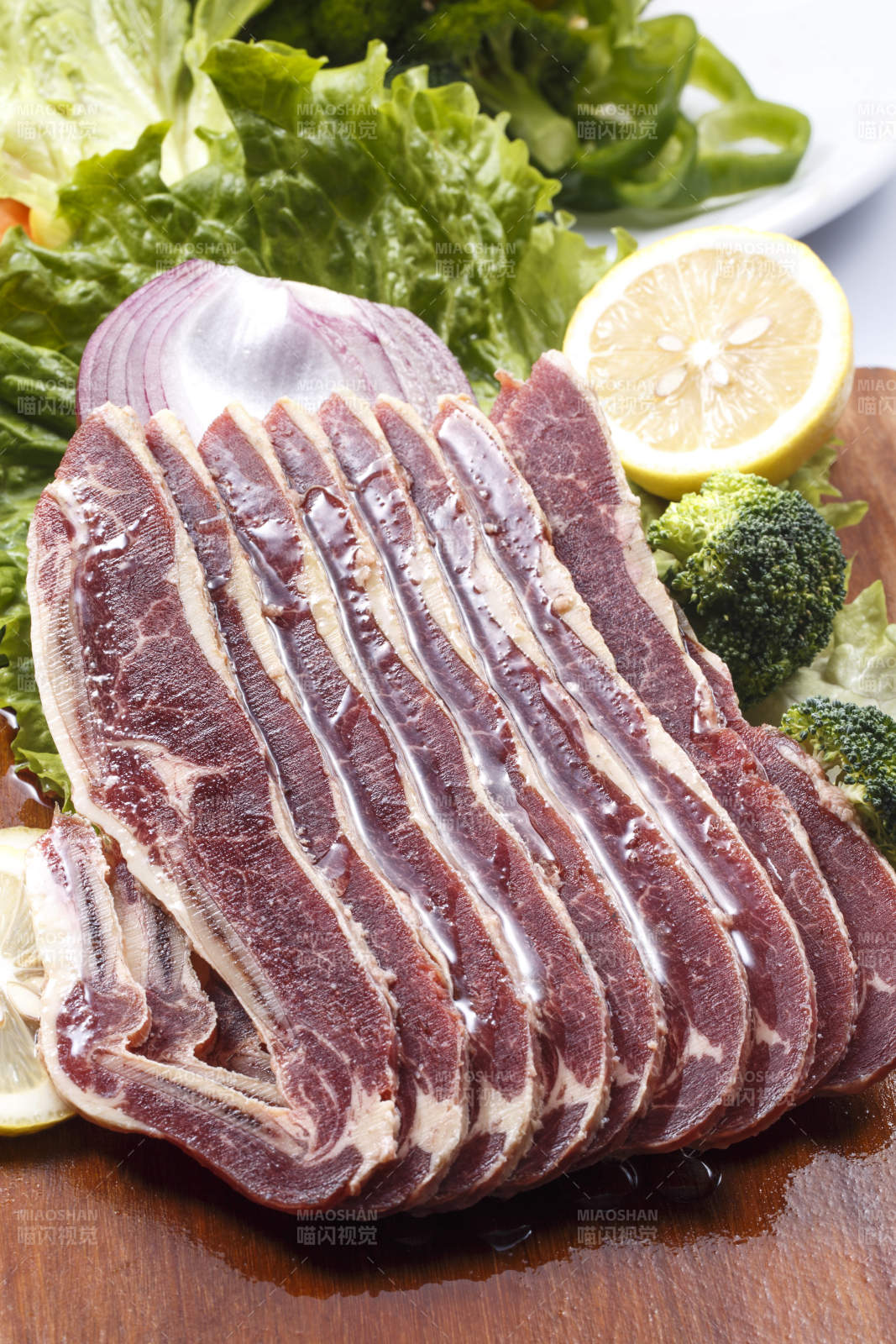 搭配檸檬洋蔥生菜的牛肋排擺放在木質砧板上