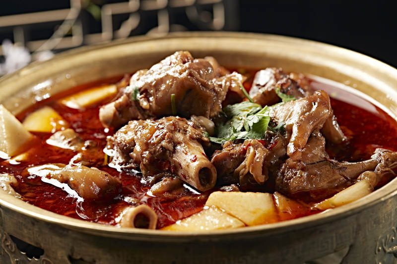 铜锅炖煮的红油香辣羊棒骨羊膝骨
