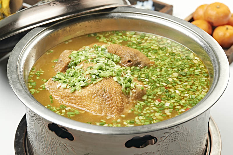 铜锅餐具装的葱香炖煮柴鸡汤