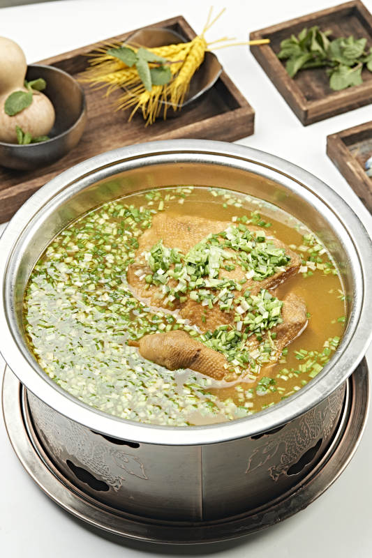 铜锅餐具装的葱香炖煮柴鸡汤