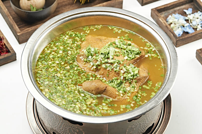 铜锅餐具装的葱香炖煮柴鸡汤